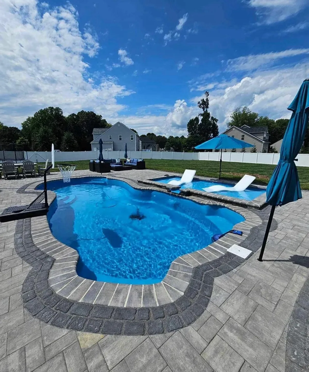 Freeform pool with a curved paver deck